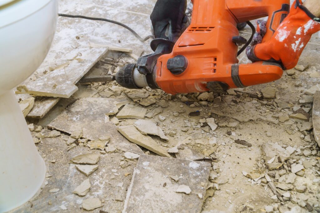 Demolition of old tiles with jackhammer. Renovation of removes old tiles from floor